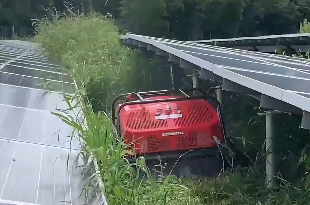 remote control wheeled lawn mower under solar panel